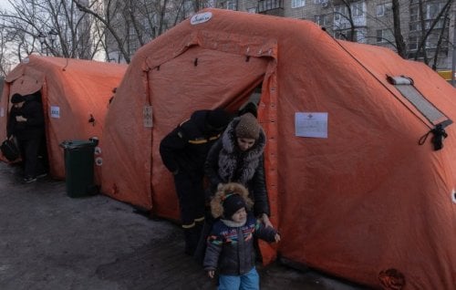 A woman and child leave an emergency service tent set up in Kyiv.